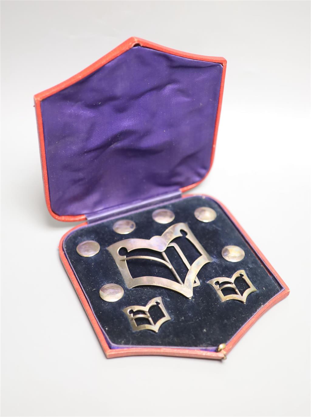 An Edwardian cased set of six silver buttons, belt buckle and pair of shoe buckles,